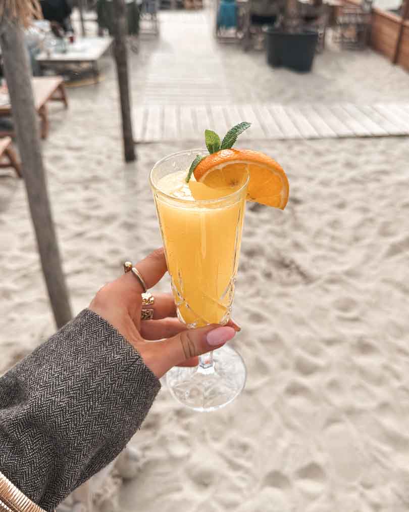 Mimosa in handen met sinaasappel en munt