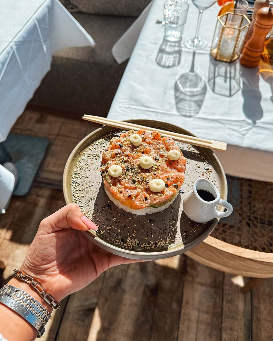 Zalm tartare in hand met stokjes en soja saus